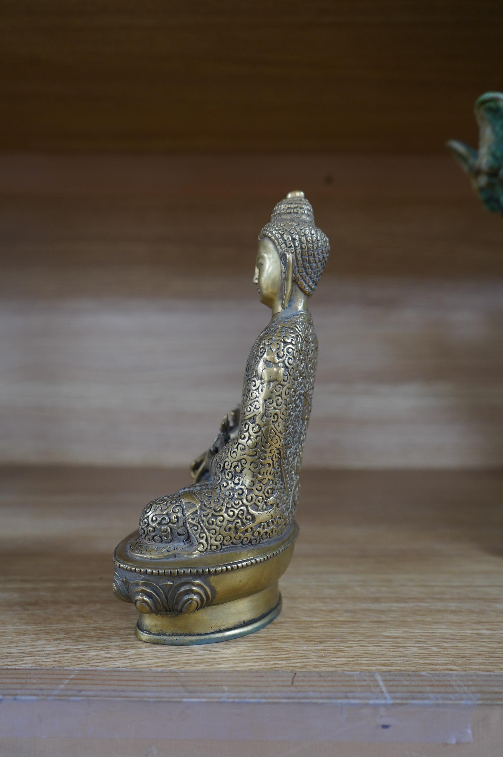 A Tibetan bronze model of a seated Buddha, 19cm. Condition - fair to good